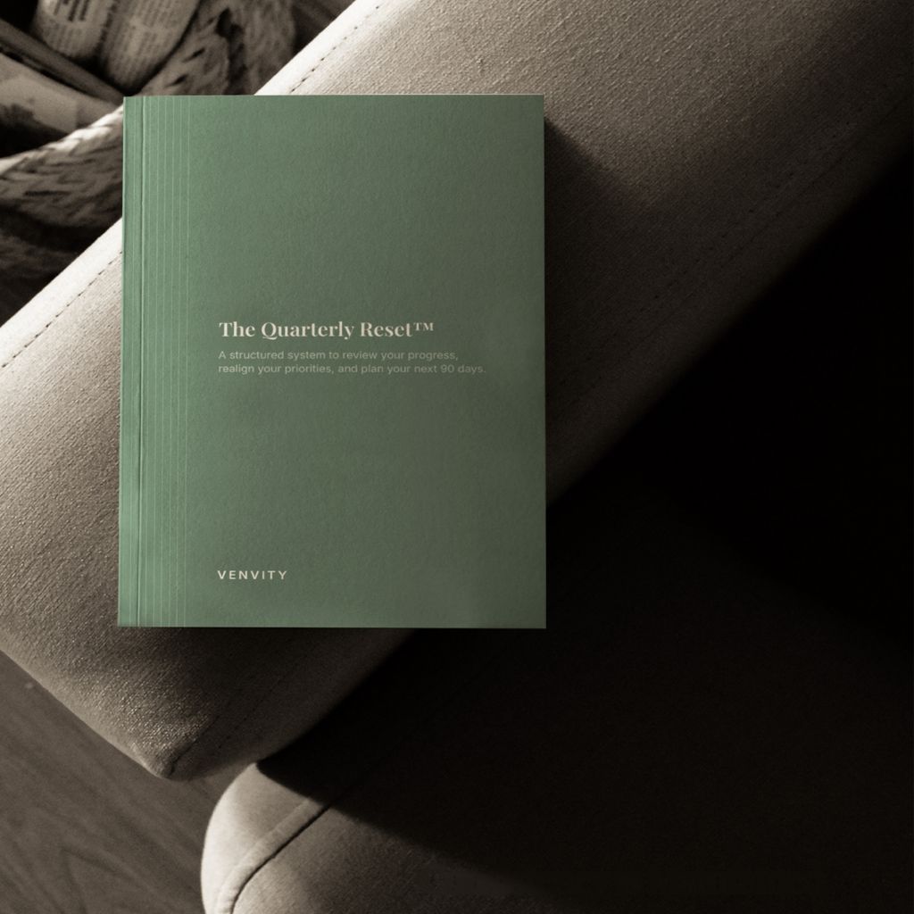 The Quarterly Reset — forest green cover on a grey sofa